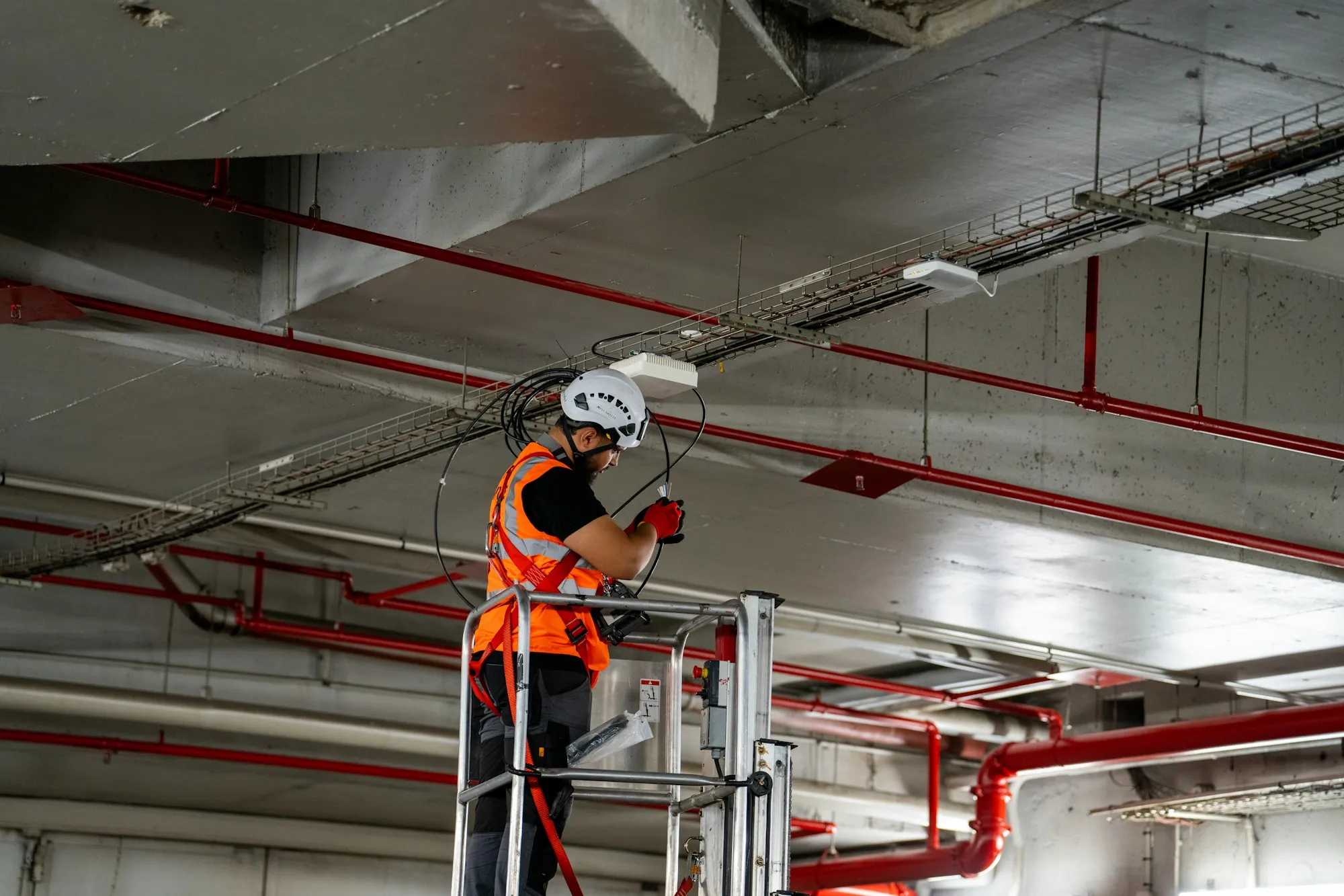 Worker on a lift doing ceiling work in a commercial building