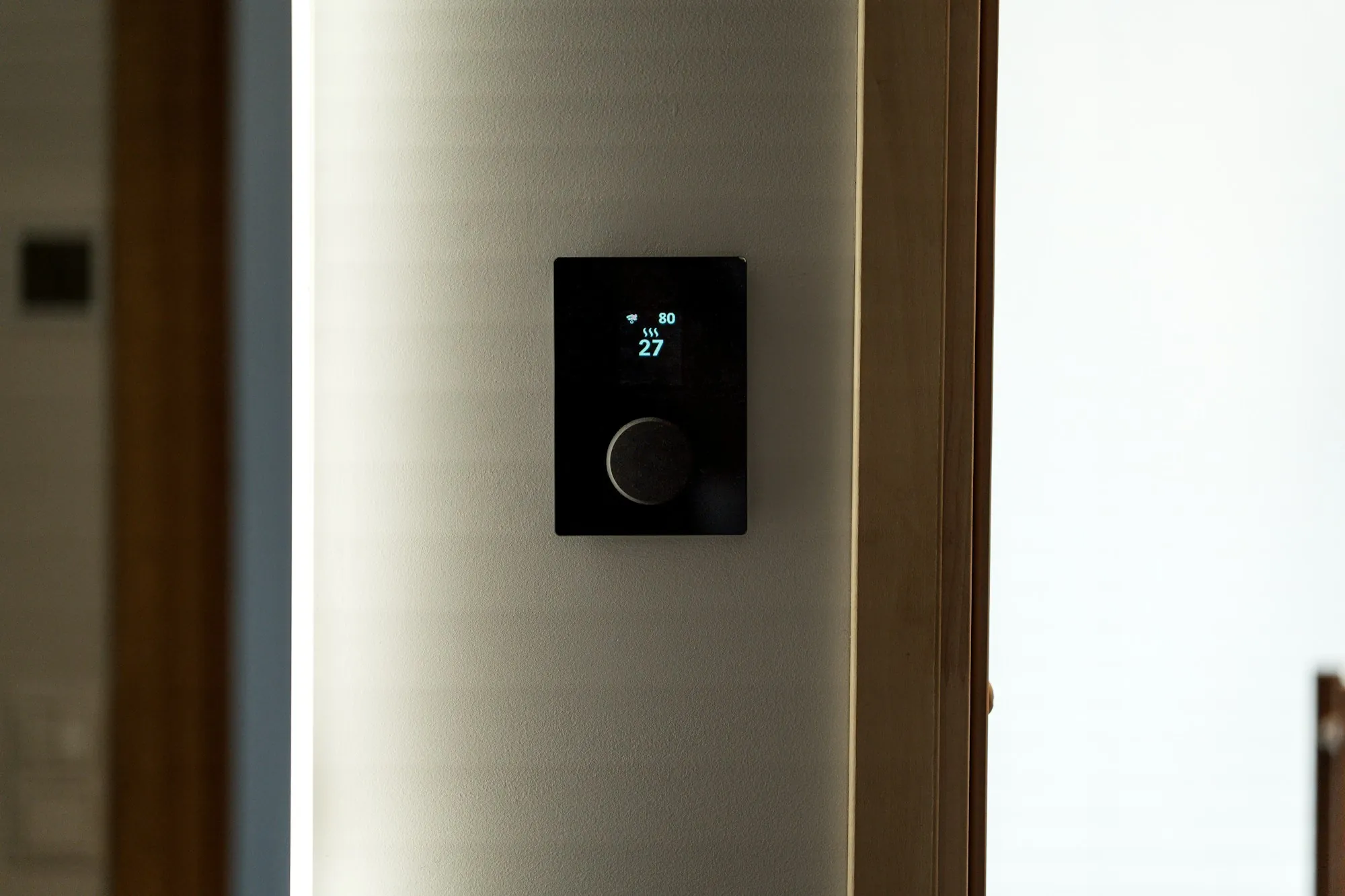 Slim digital thermostat on a white wall