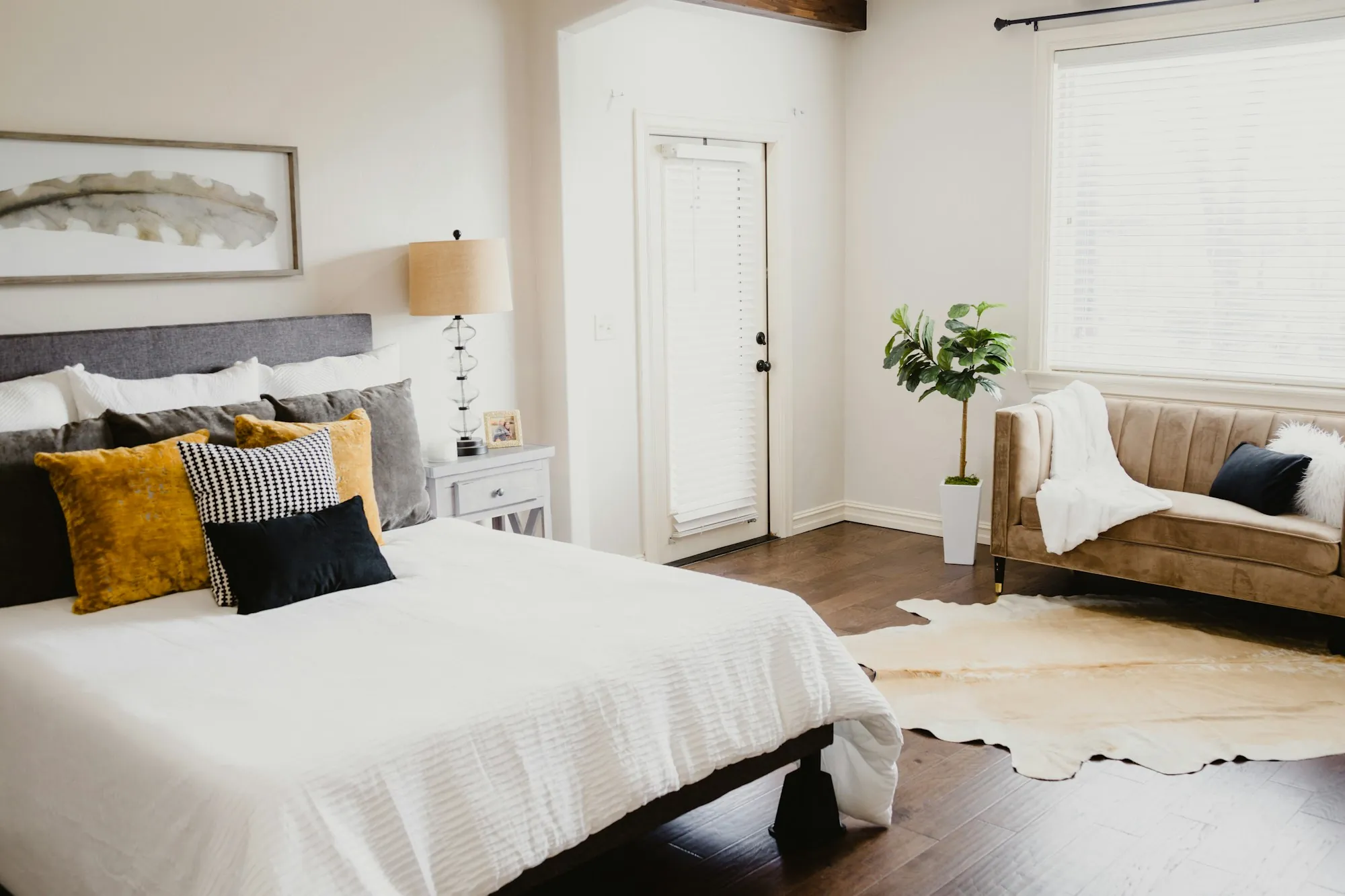 Airy bedroom with white bedding and yellow pillows